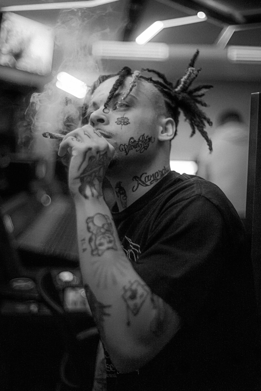 a man with dreadlocks smoking a cigarette