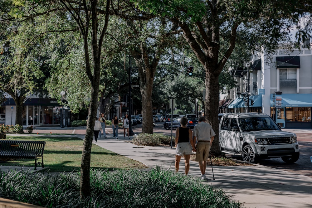 a couple of people walking down a sidewalk