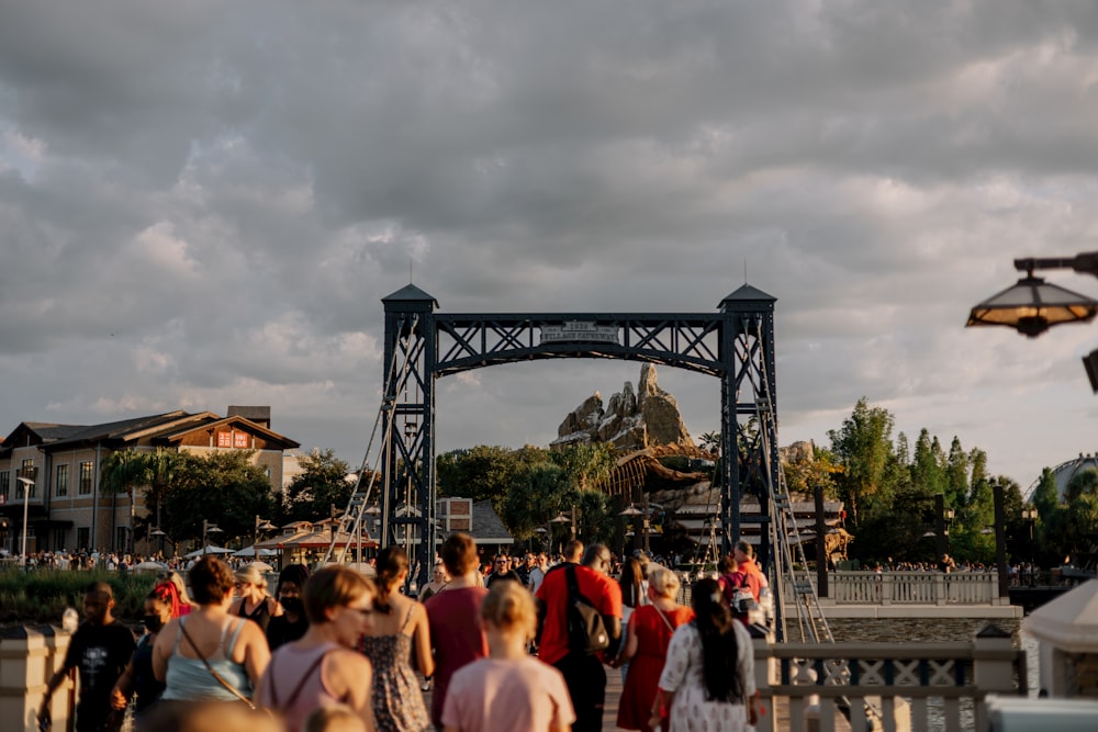 a crowd of people walking across a bridge