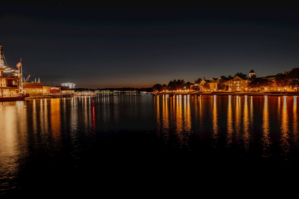 a large body of water at night with buildings in the background