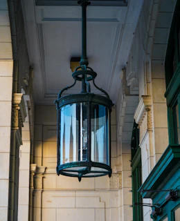 Vintage lantern hanging in a delicate archway surrounded by intricate stucco work.