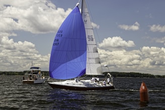 a sailboat in the water with a buoy in the foreground