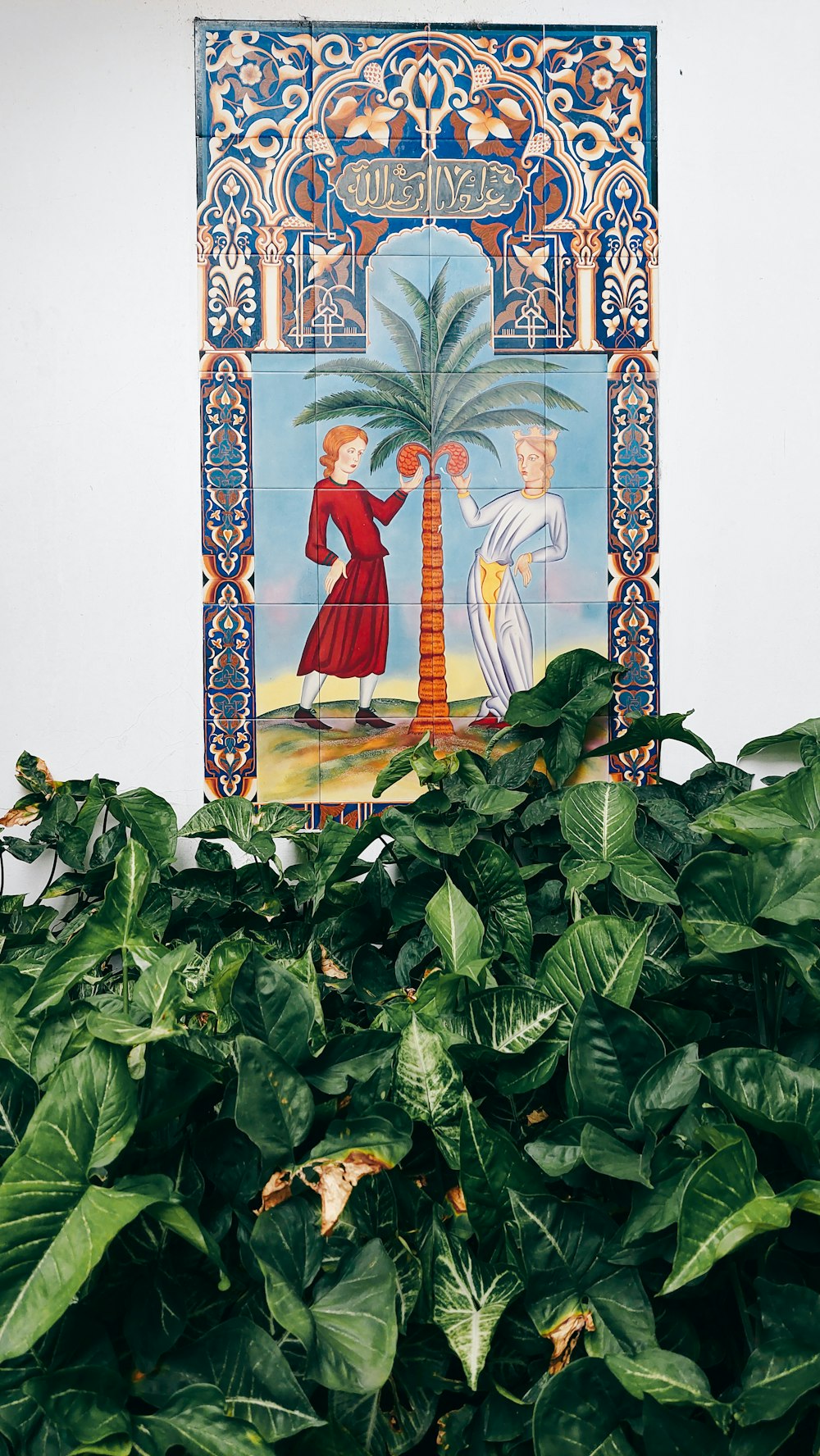 a painting on a wall above a potted plant