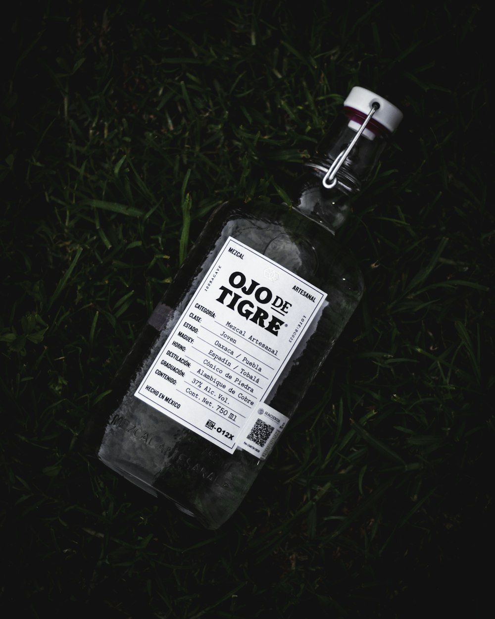 a bottle of liquor sitting in the grass