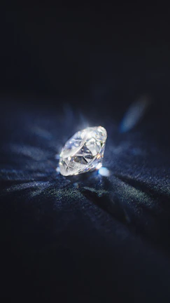 Elegant emerald-cut diamond resting on a velvet cushion.