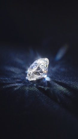 Brilliant cut diamonds sparkling with reflections on a dark surface