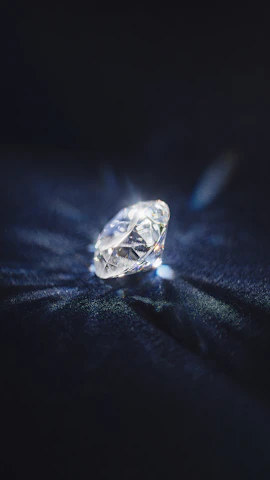 Elegant oval-shaped diamond catching light on a sleek black background.