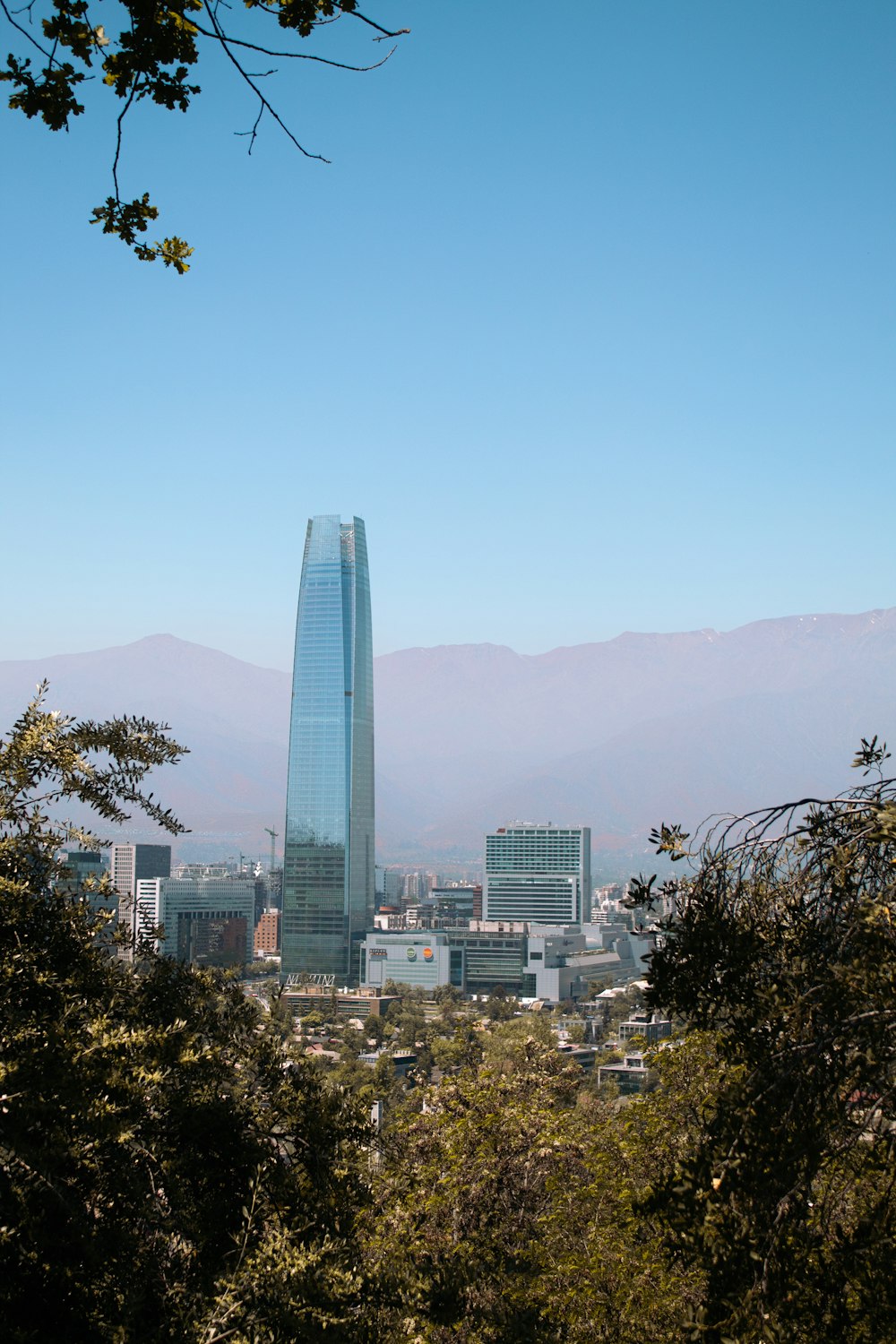 a view of a city with tall buildings and mountains in the background