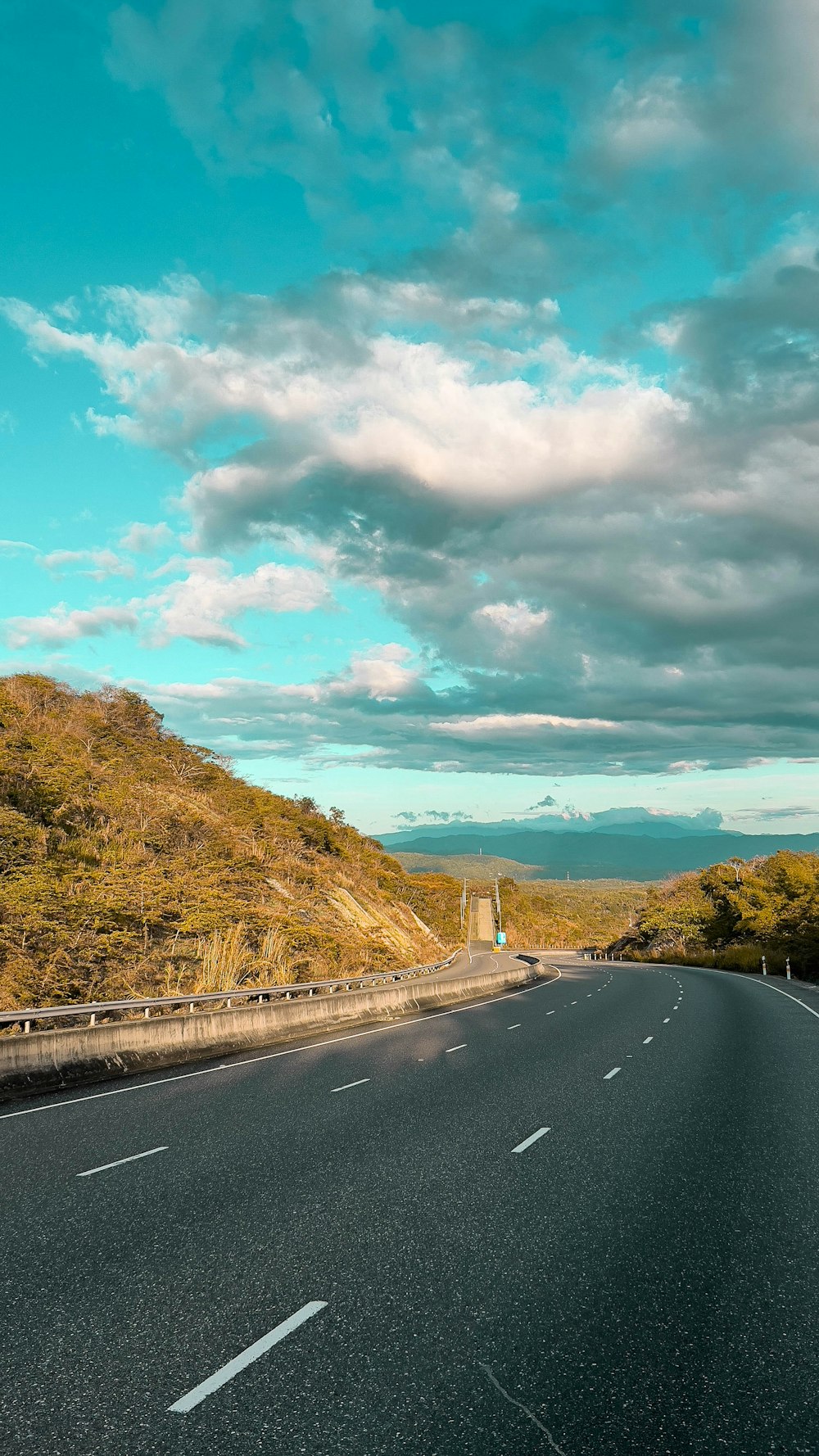 a long road with a hill in the background