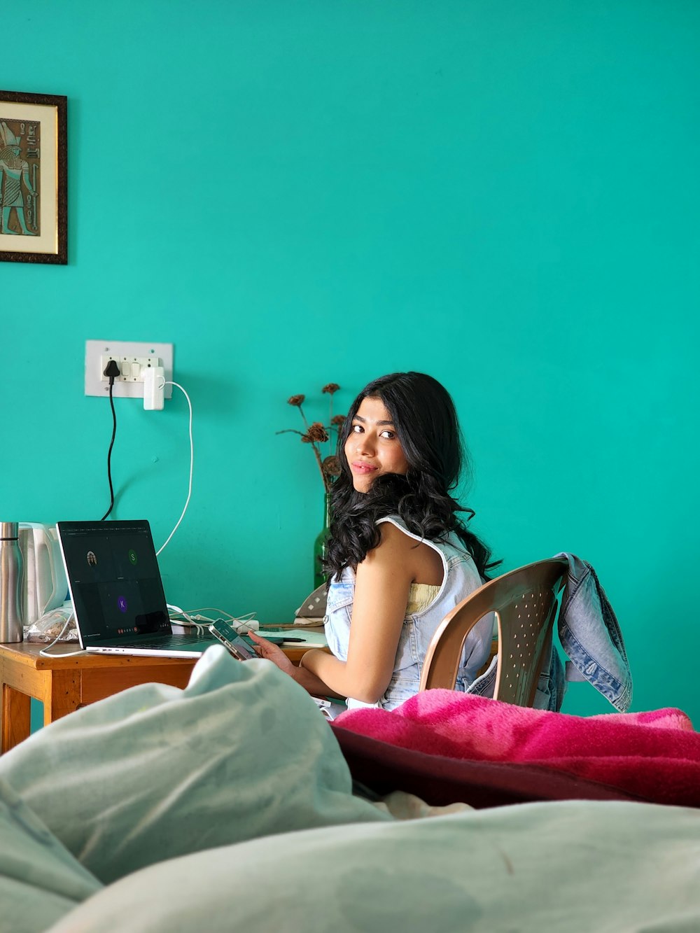 a woman sitting on a bed with a laptop