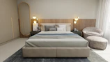 A modern bedroom with a large bed featuring neutral-colored bedding. The headboard has a textured wood design, and there are two round wall lamps on each side. A sleek, dark green nightstand holds a small framed picture and a book. To the right, there is a cozy round chair with a matching ottoman on a textured area rug. A full-length mirror stands against the wall near a wardrobe. Soft, natural light filters through sheer curtains.