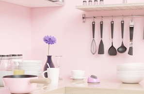 a pink kitchen with utensils hanging on the wall
