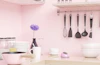 a pink kitchen with utensils hanging on the wall