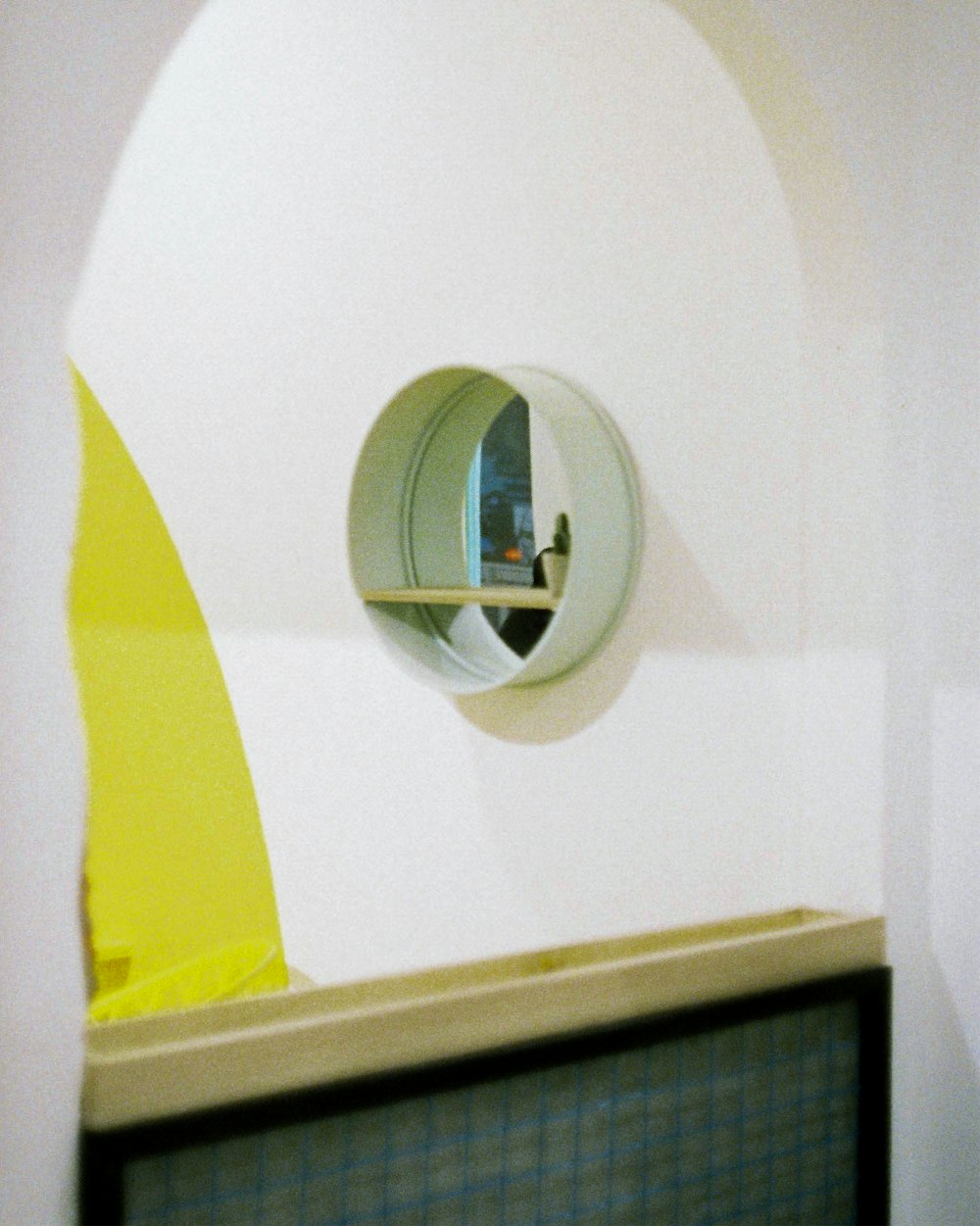 a round mirror on the wall of a bathroom