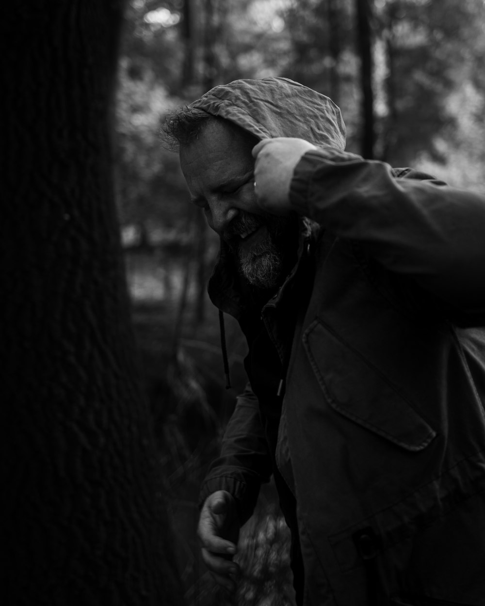 a man with a beard standing in the woods