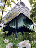 a very tall building sitting on top of a lush green hillside
