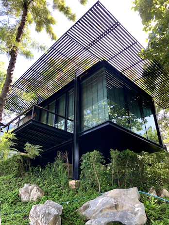 a very tall building sitting on top of a lush green hillside