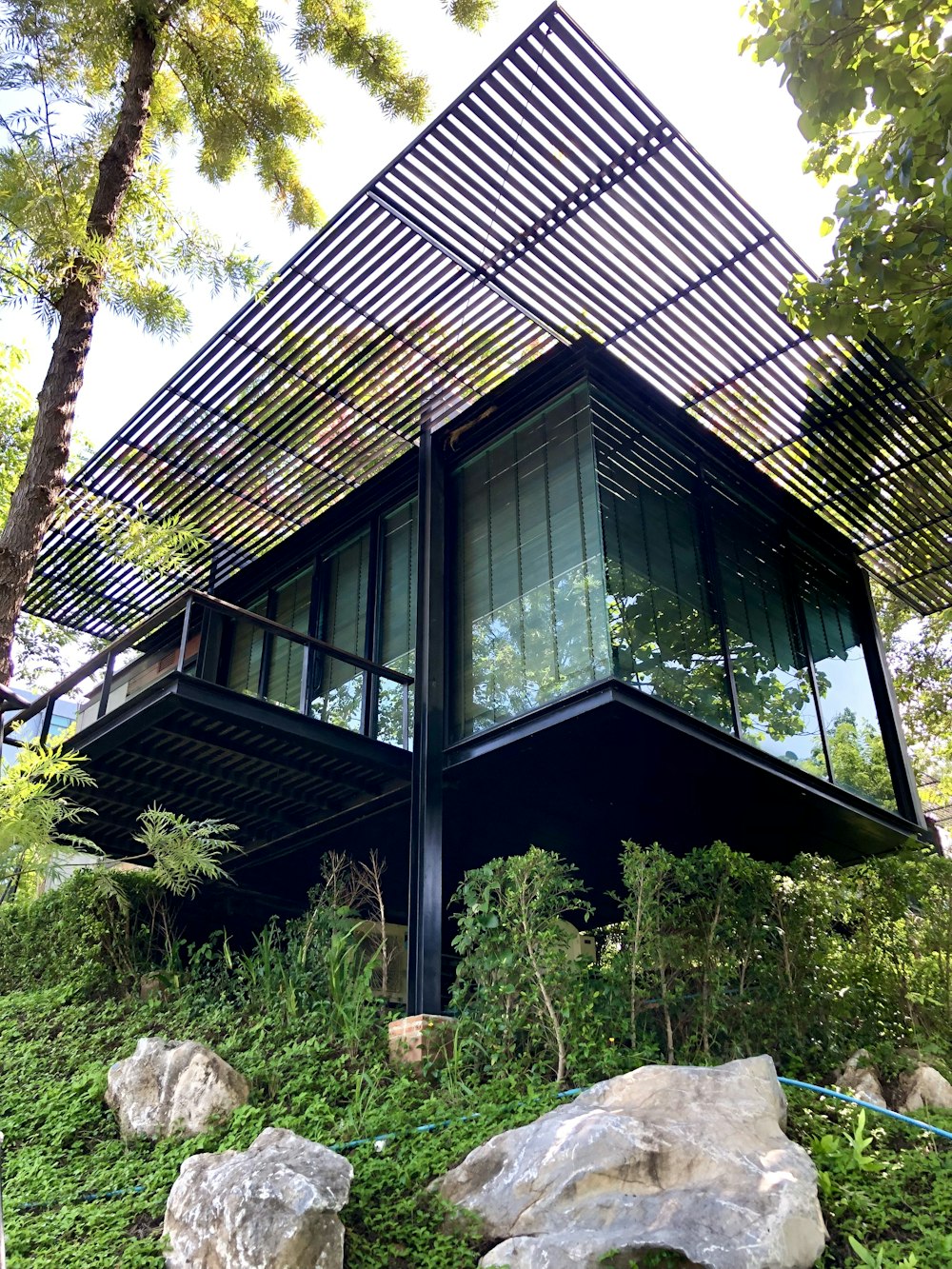 a very tall building sitting on top of a lush green hillside