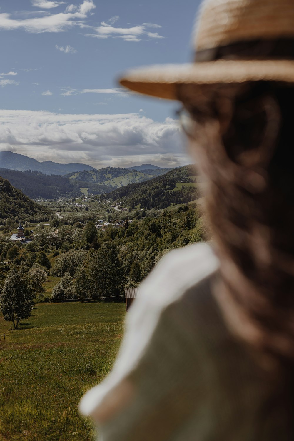 a person with a hat looking at a valley