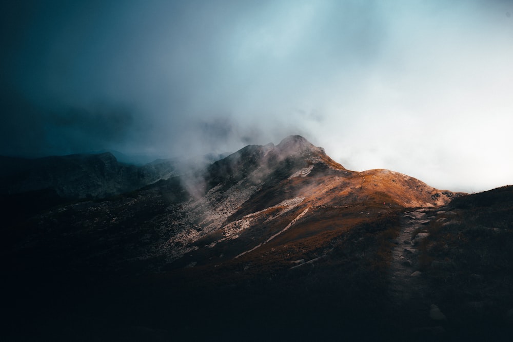 a view of a mountain in the distance under a cloudy sky