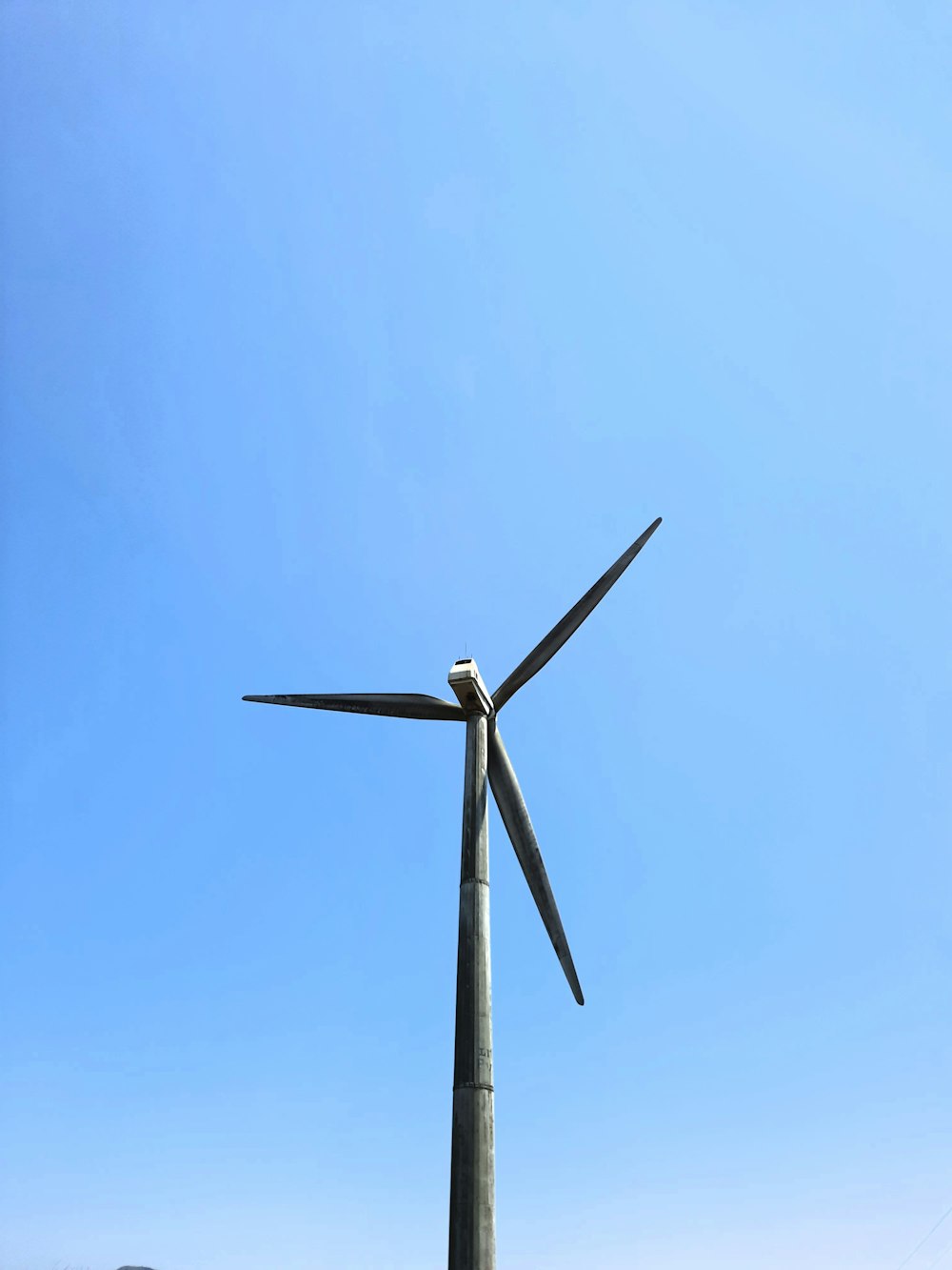 a wind turbine is shown against a blue sky