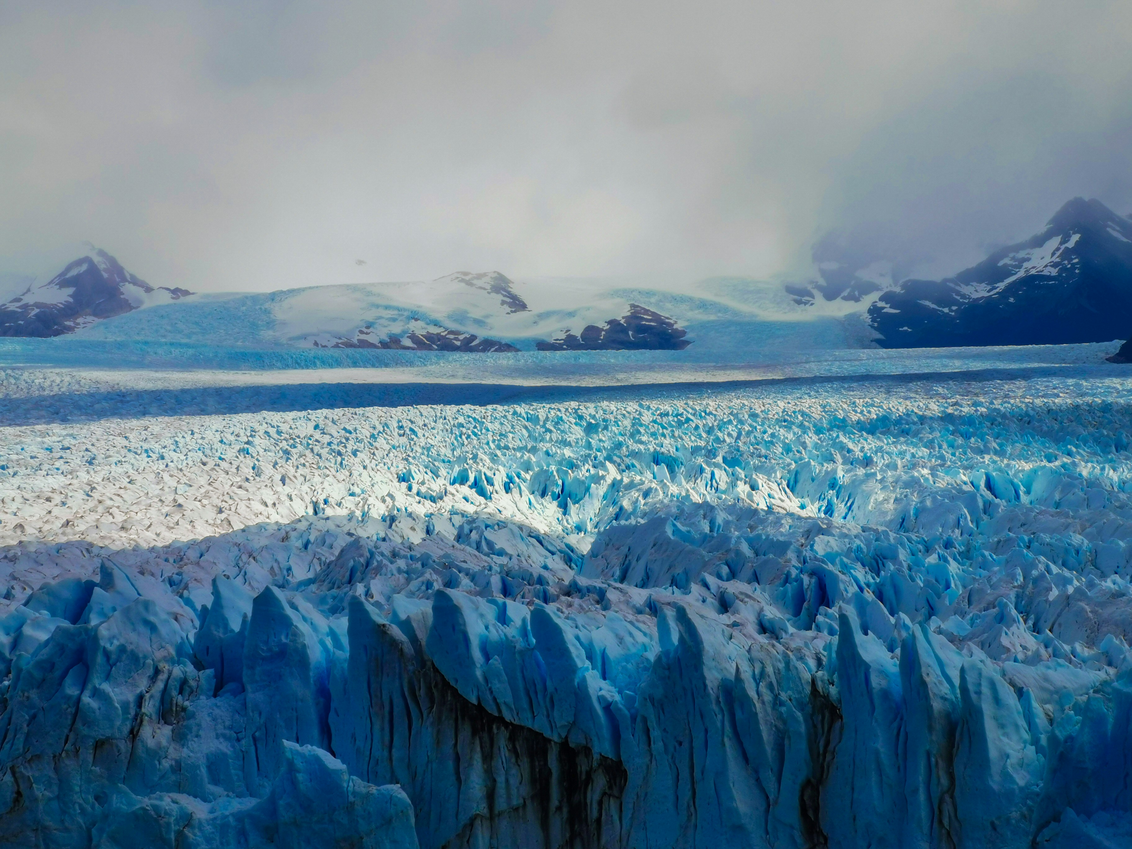 a large glacier with mountains in the background, The Moreno Glacier in Argentiina