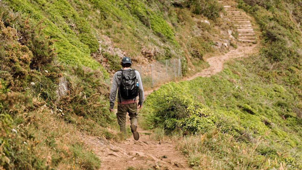 a man with a backpack walking up a hill