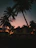 Cozy villa terrace overlooking palm trees with soft evening lighting.
