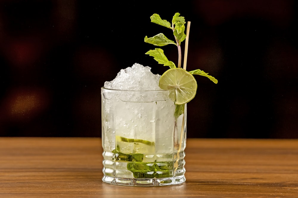 a glass filled with ice and a lime garnish