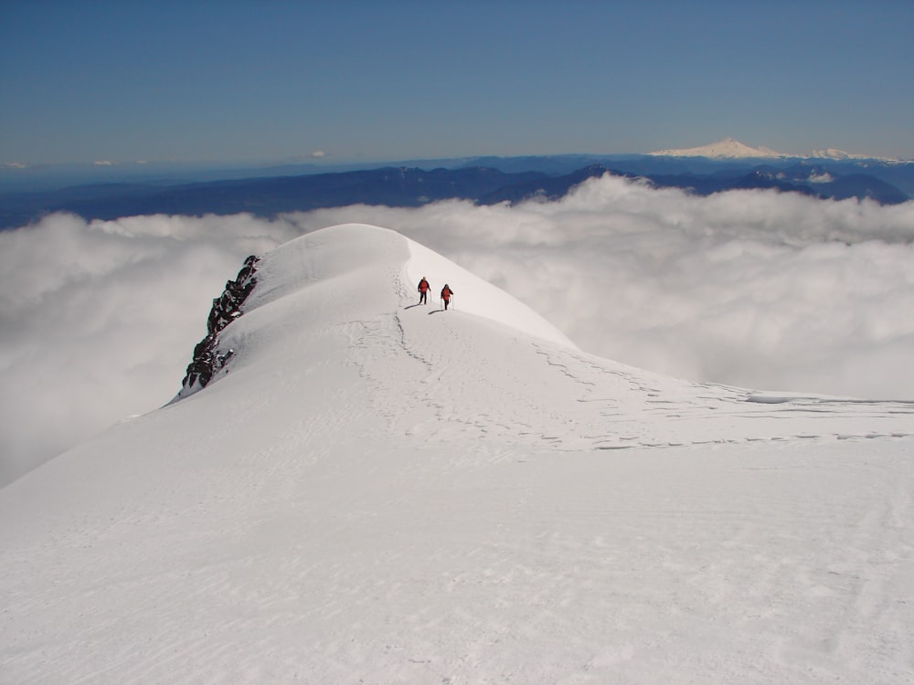 a group of people hiking up the side of a snow covered mountain
