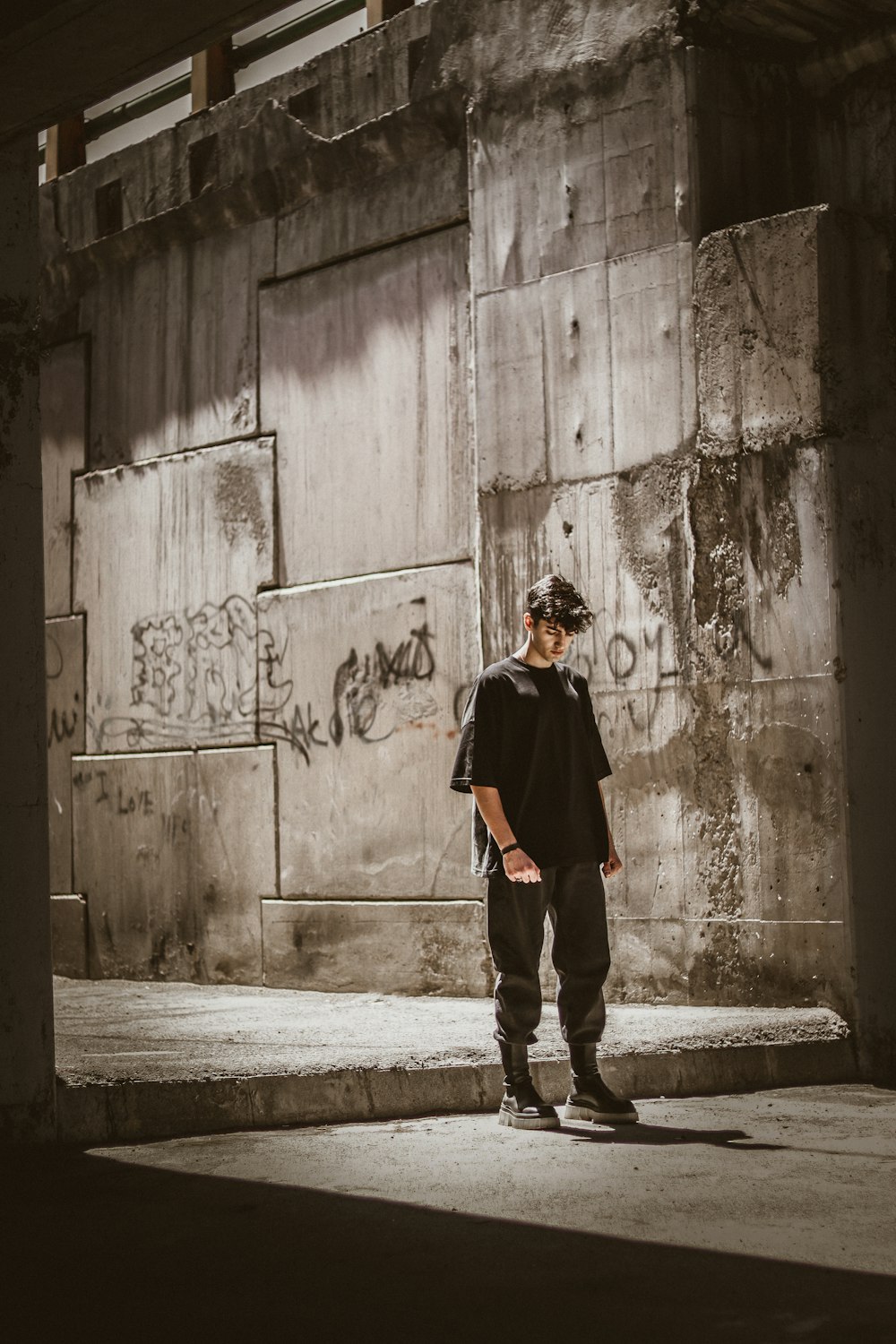 a man standing in front of a wall with graffiti on it