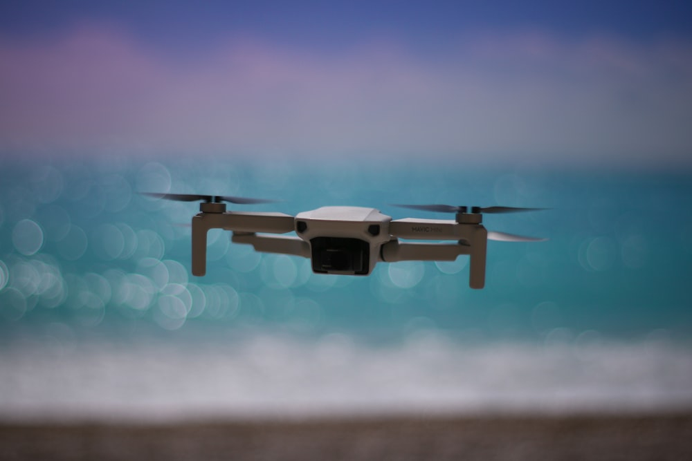 a close up of a small white object flying over the ocean