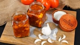 a wooden cutting board topped with jars of food