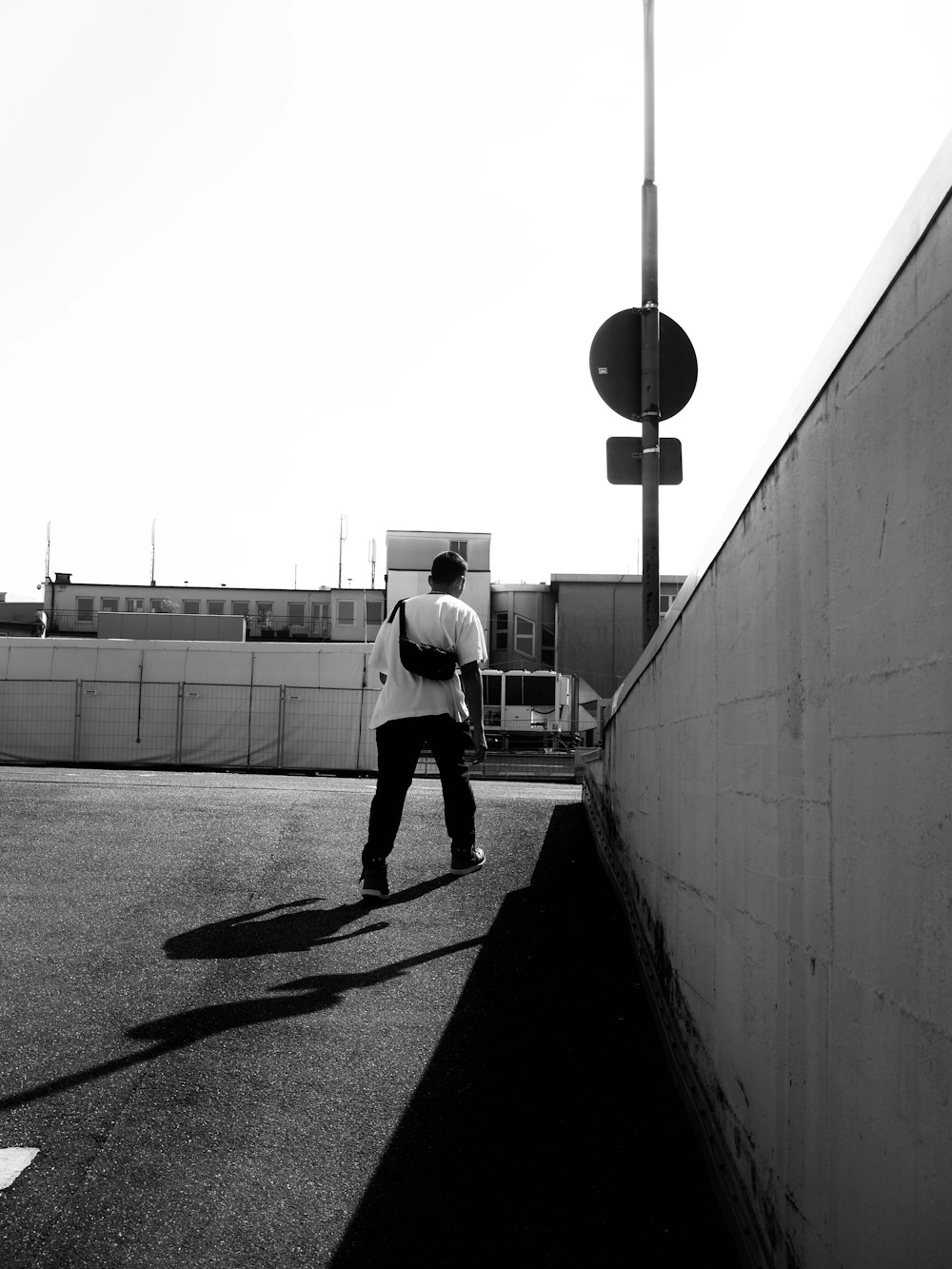 a man walking down a street next to a traffic light