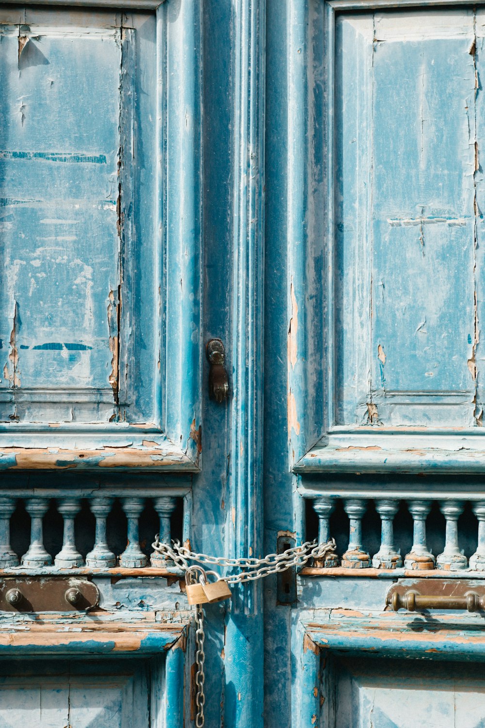 a close up of a blue door with a chain on it