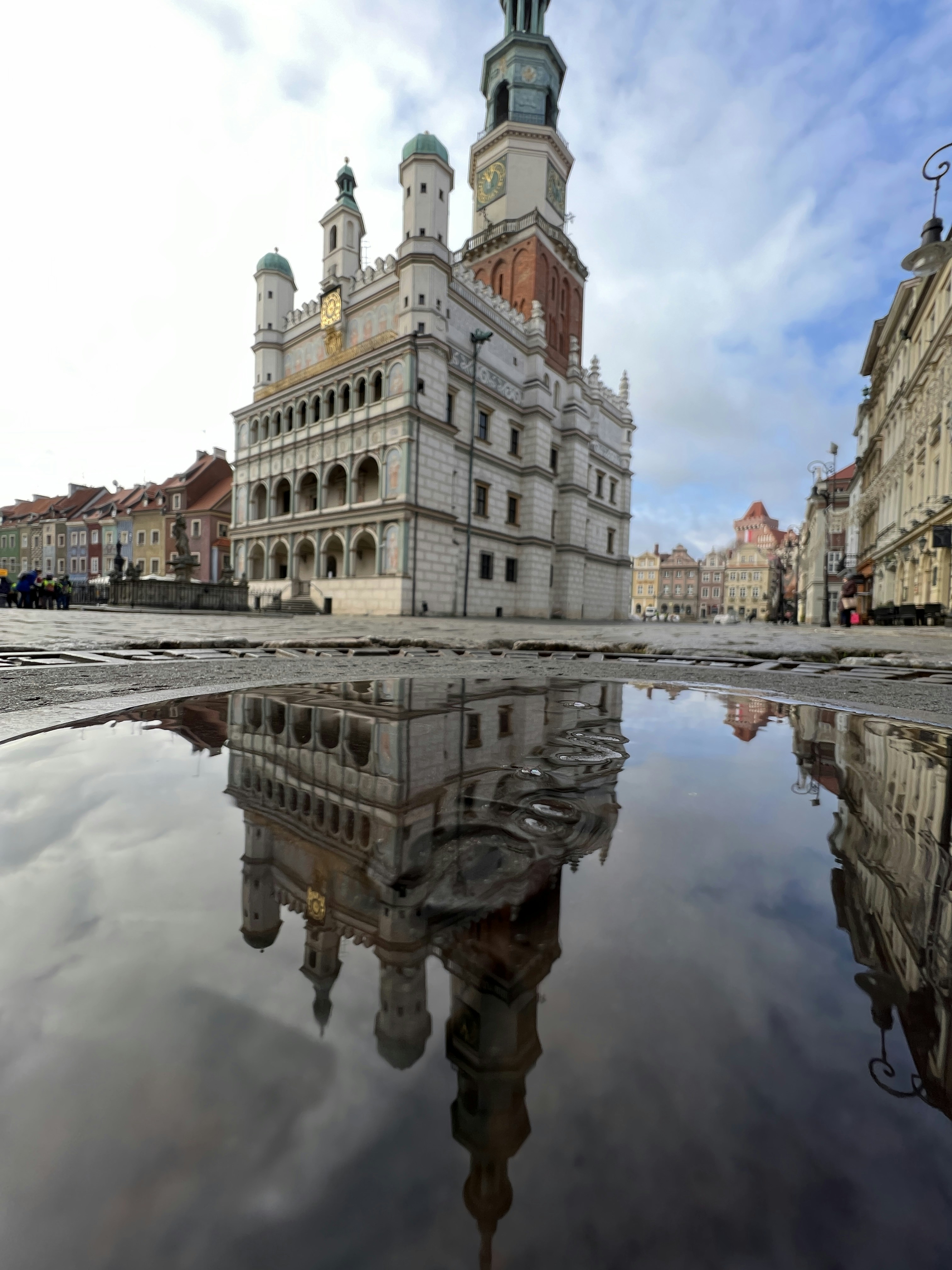 Great reflection picture of Poznań Town Hall in a puddle after the rain. It has great color and great skys. Neat picture of down town poznan / city center.