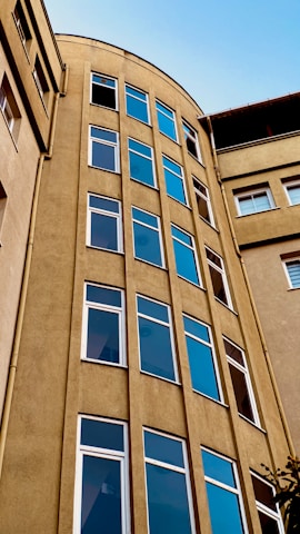 a tall building with lots of windows next to a tree