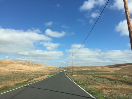 a long road with a telephone pole in the middle of it