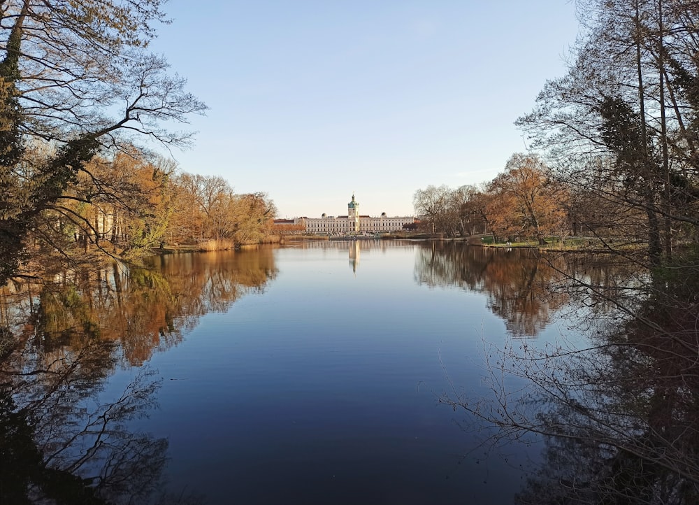 a body of water surrounded by trees and a bridge