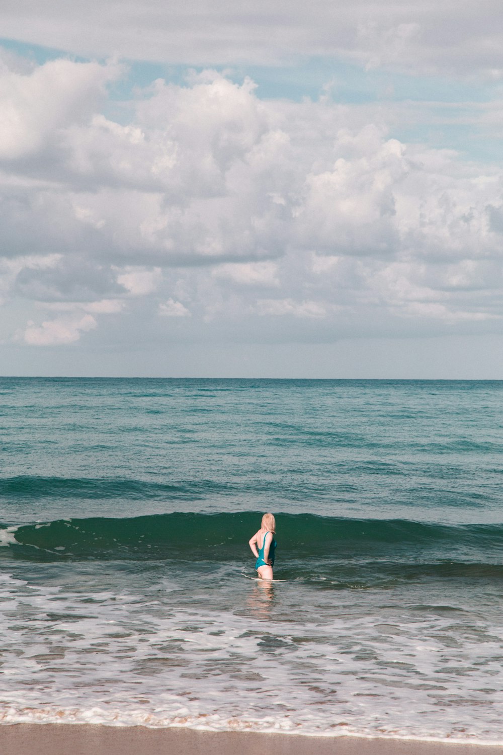 a person standing in the ocean with a surfboard