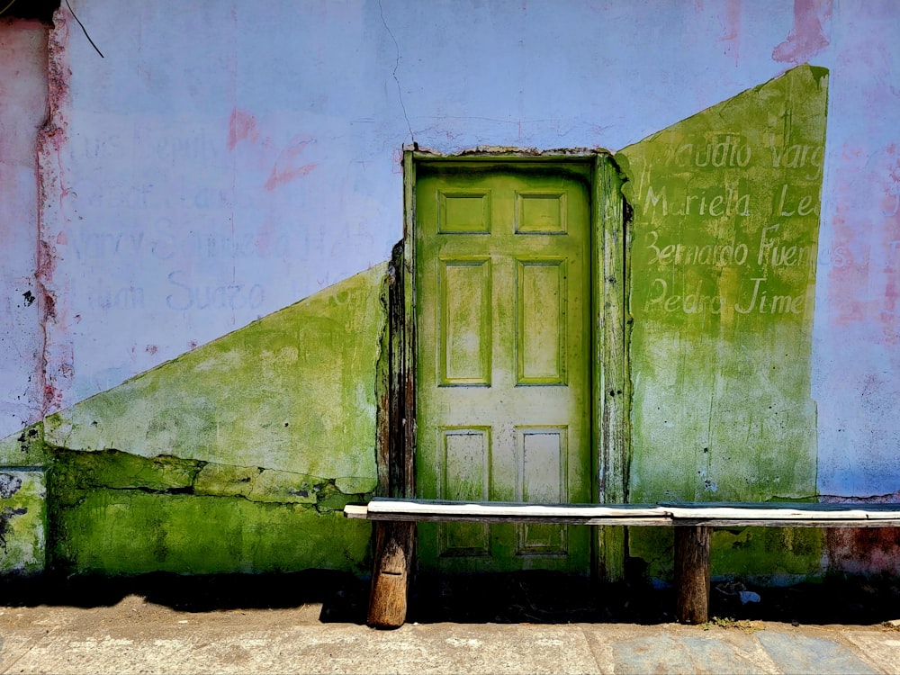 a bench in front of a green door