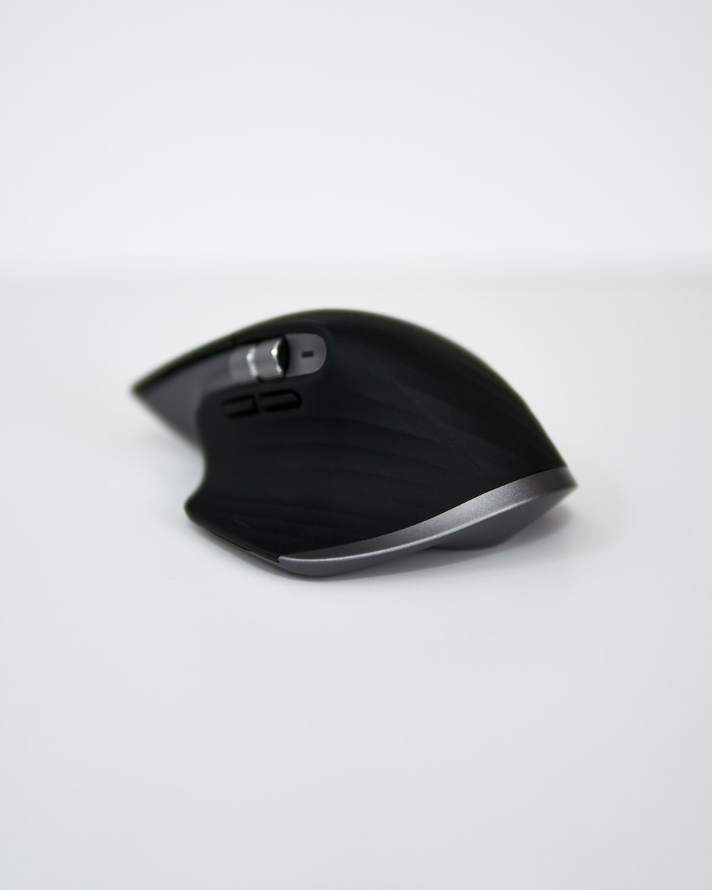 a black computer mouse sitting on top of a white table