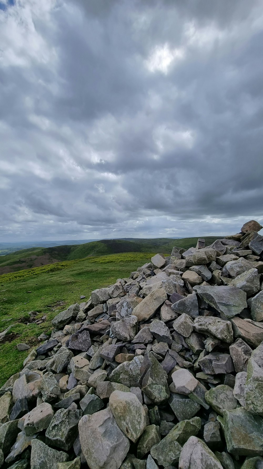 a pile of rocks sitting on top of a lush green field