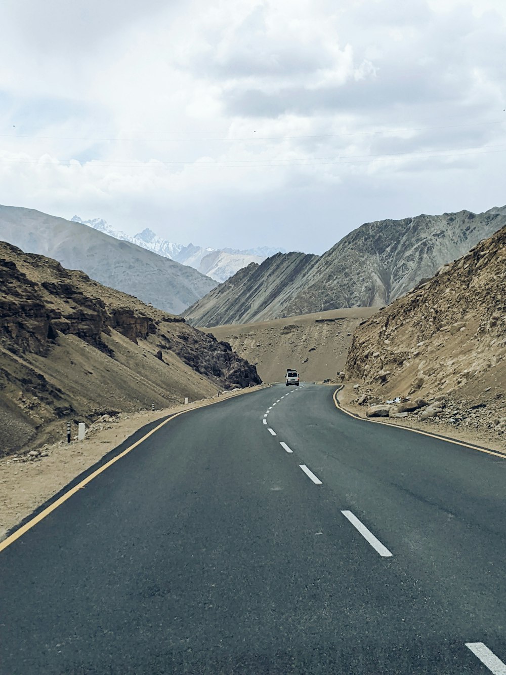 a car driving down a road in the mountains