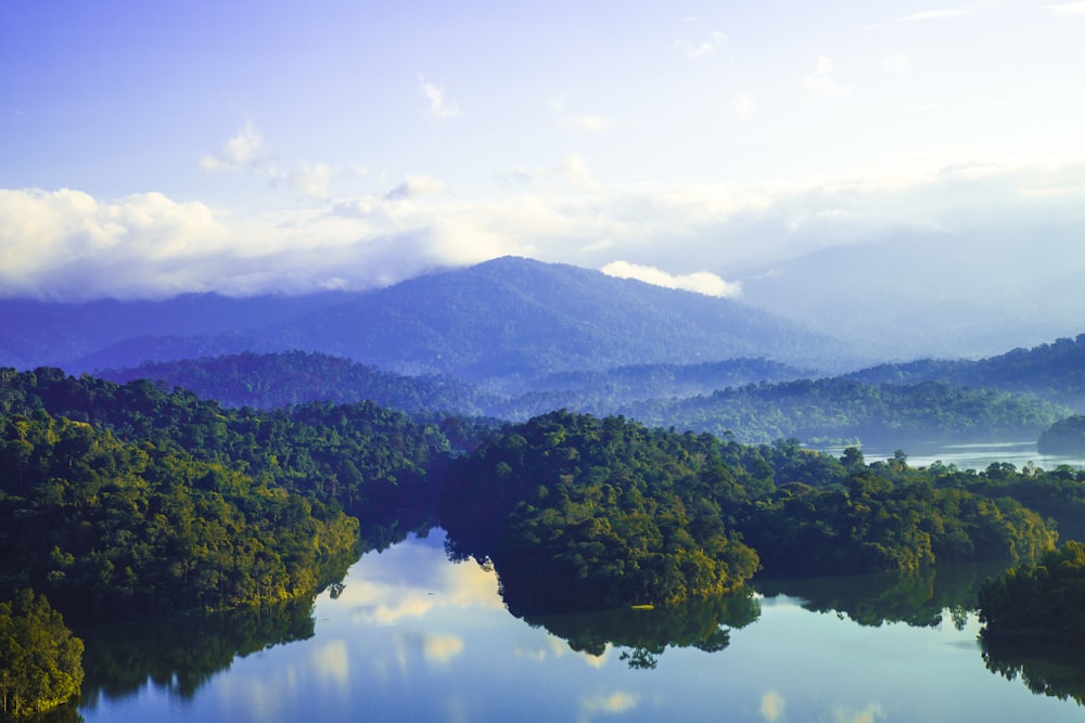 a lake surrounded by lush green trees and mountains