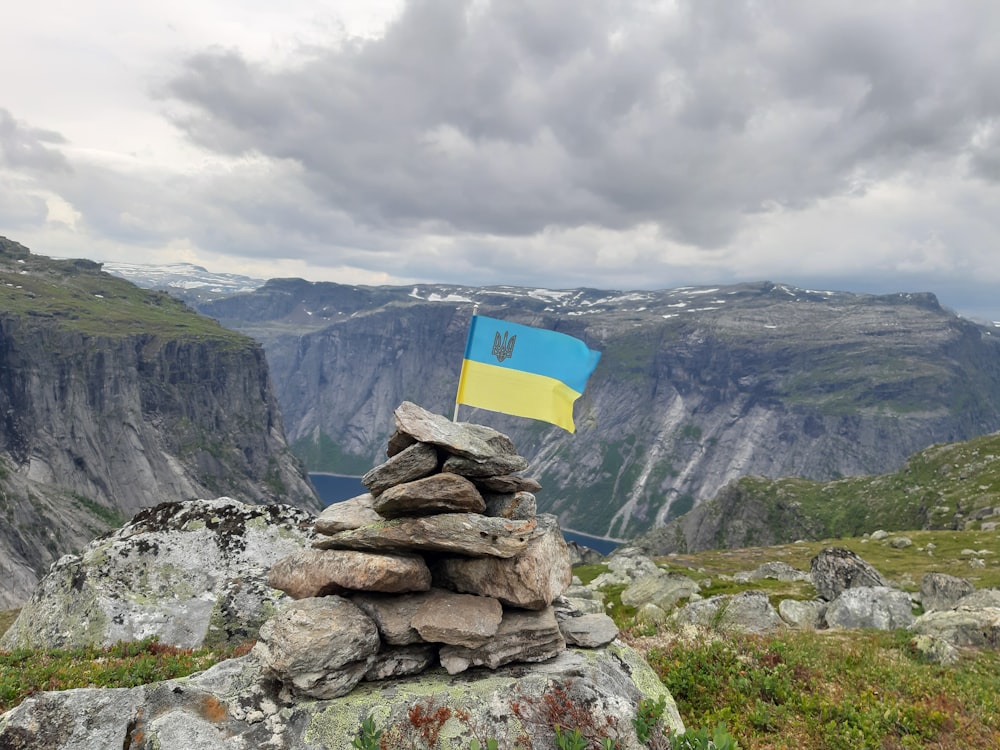 a pile of rocks with a flag on top of it