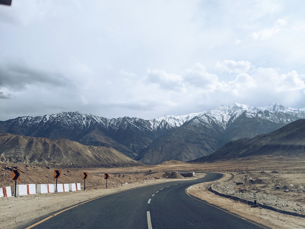 an empty road with mountains in the background