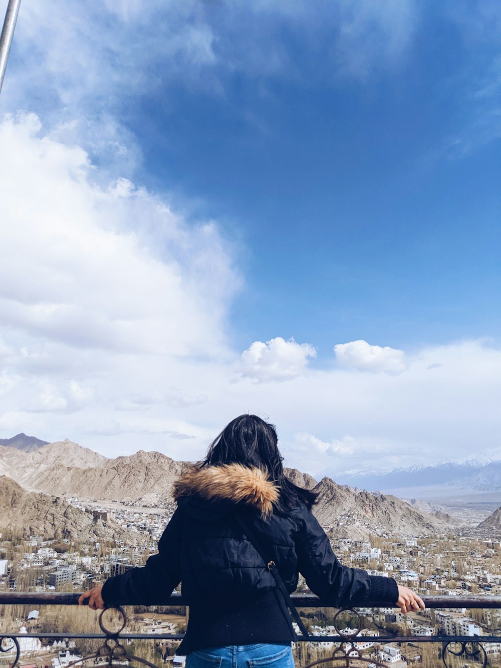 a woman standing on a balcony overlooking a city