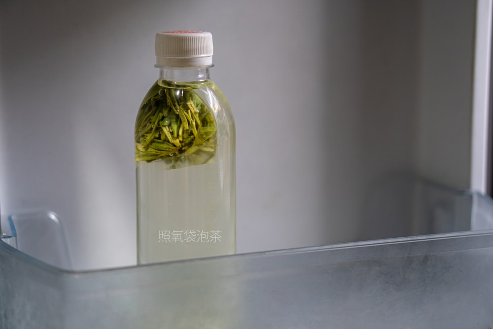 a bottle filled with green tea sitting on top of a counter