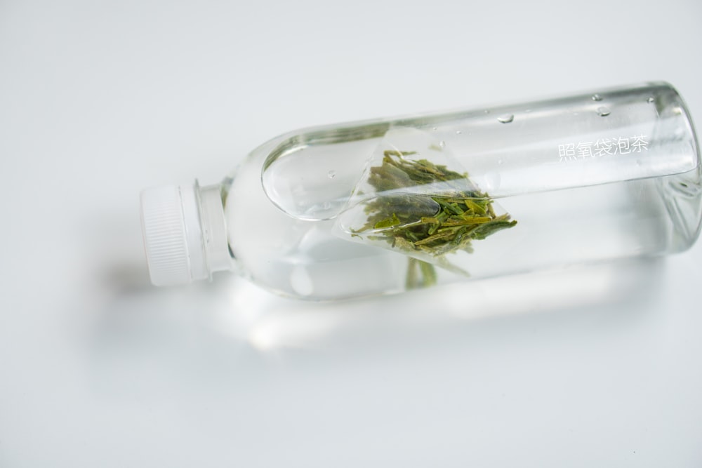 a glass bottle filled with water and flowers